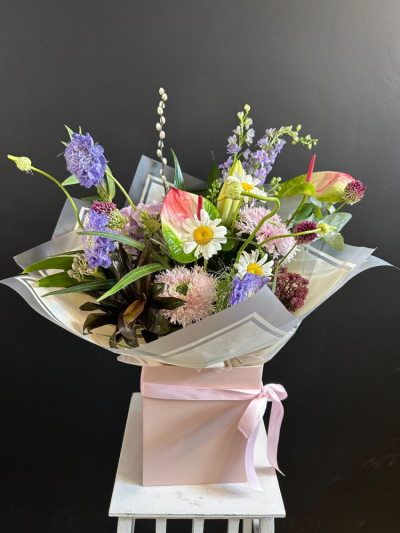 Sweet Serenity - A beautifully arranged hand-tied bouquet featuring seasonal flowers in soft pink, lilac and white tones, expertly gift wrapped by a local florist.